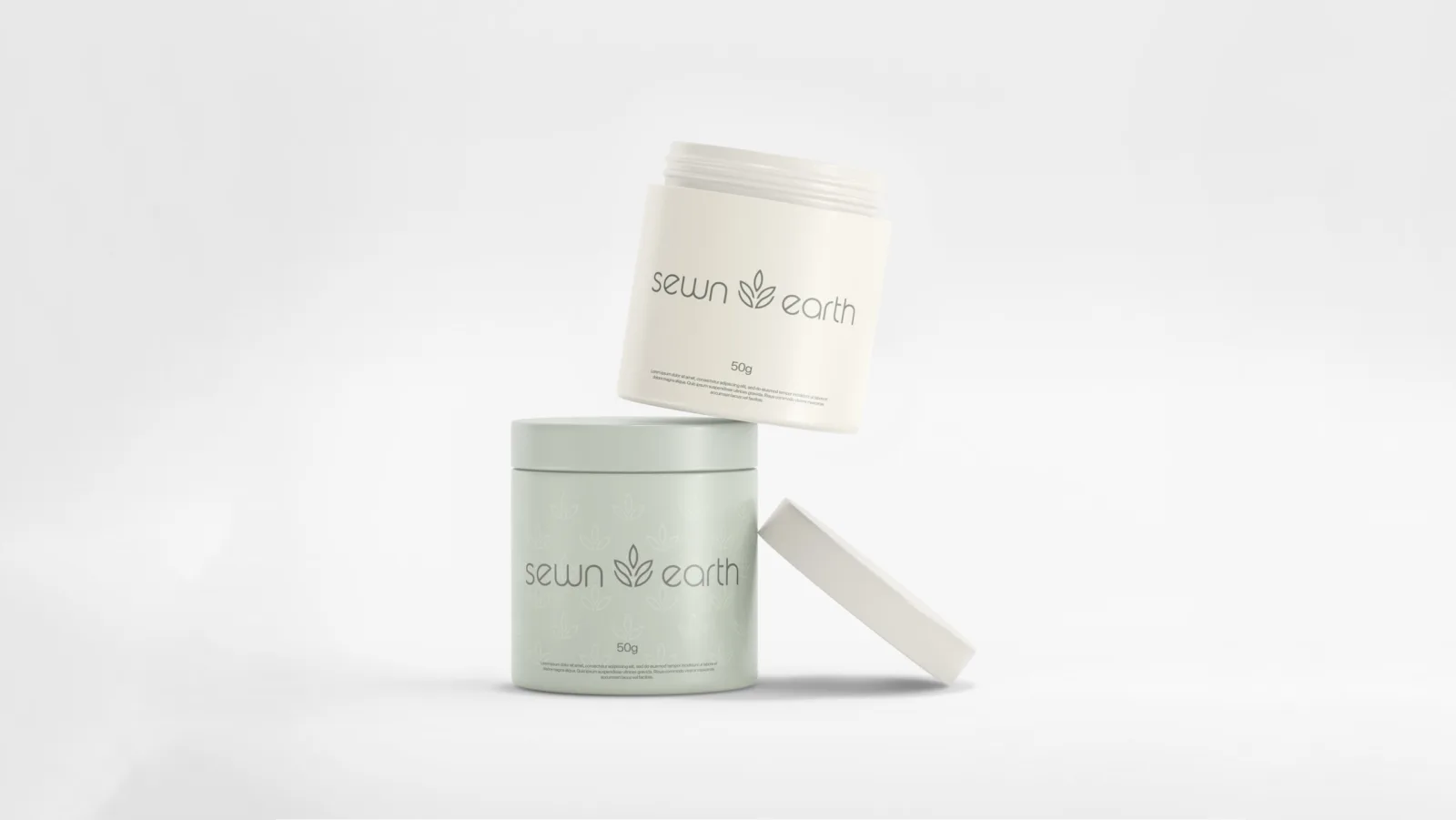 Two Sewn Earth skincare jars in cream and sage green with the leaf logo